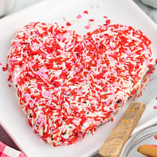 This Toffee Chocolate Chip Cheeseball is the perfect dip to serve on Valentine’s Day! It tastes like cheesecake with toffee bits and chocolate chips and it’s covered in festive sprinkles. Customize it for any holiday!