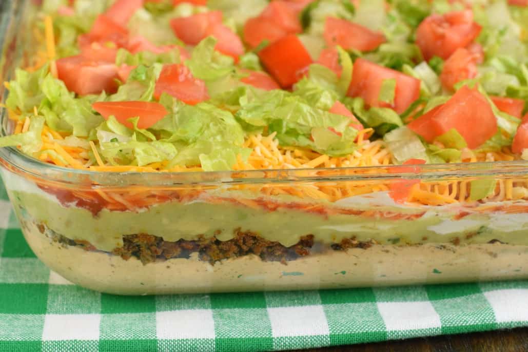 7 Layer Dip packed with layers of Cream Cheese, Sour Cream, Ground Beef (and/or Beans), Guacamole, Salsa, Cheese, and more! 