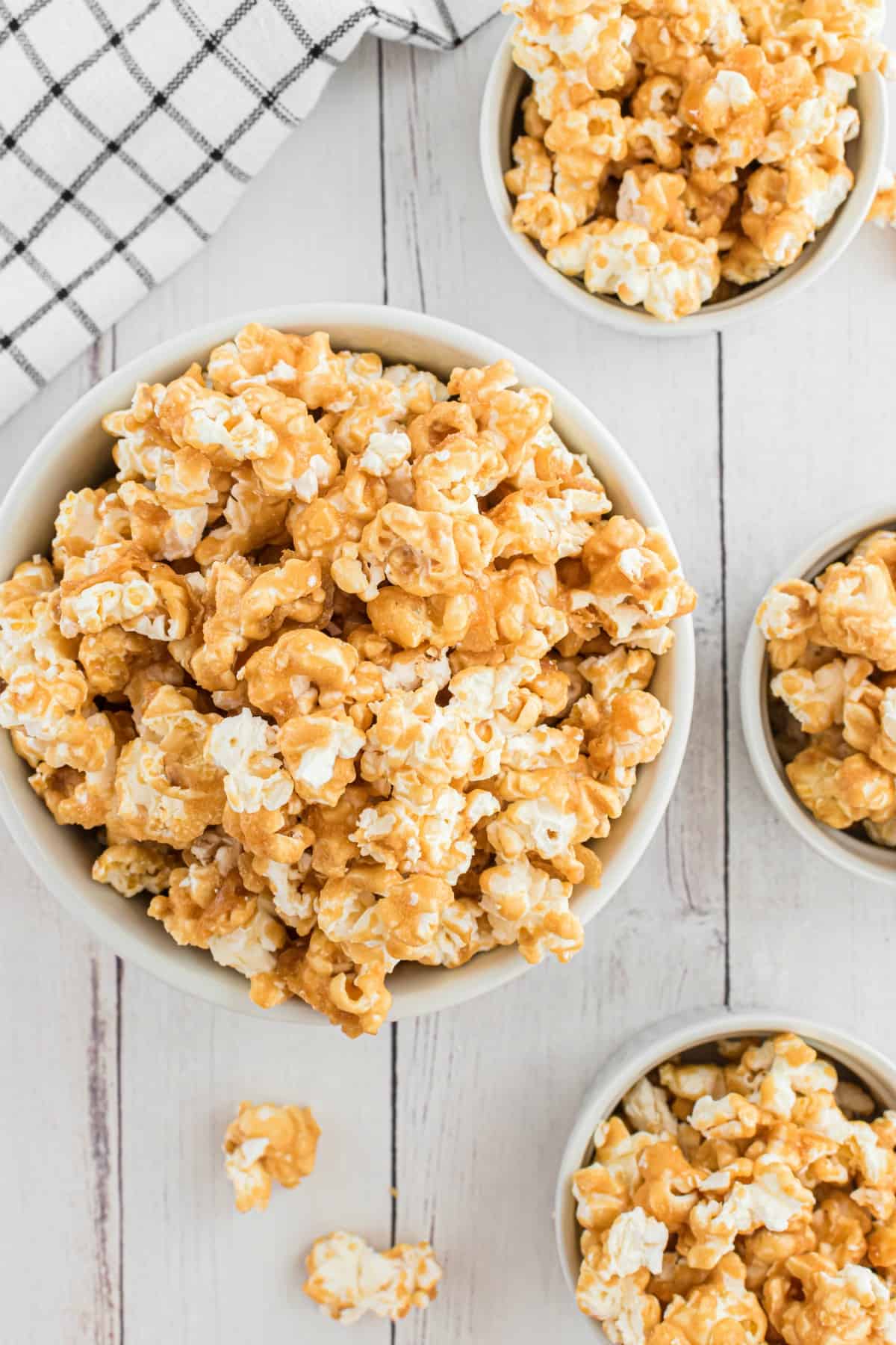 Caramel corn in 4 different sized bowls.
