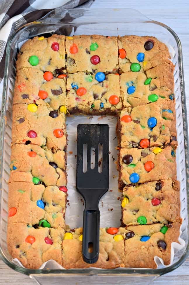 M&M Chocolate chip cookie bars in a 13x9 pan with several bars removed.