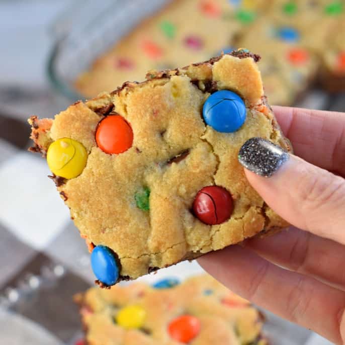 Close up of slice of chocolate chip cookie bar with colorful m&m candies.