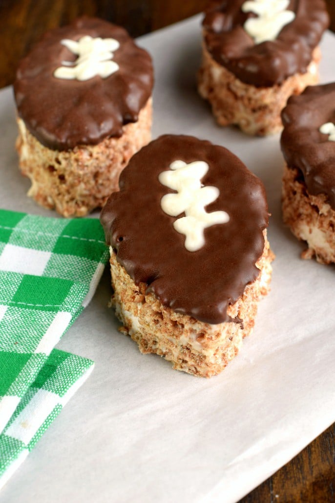 Football shaped cocoa krispie treats topped with melted chocolate.