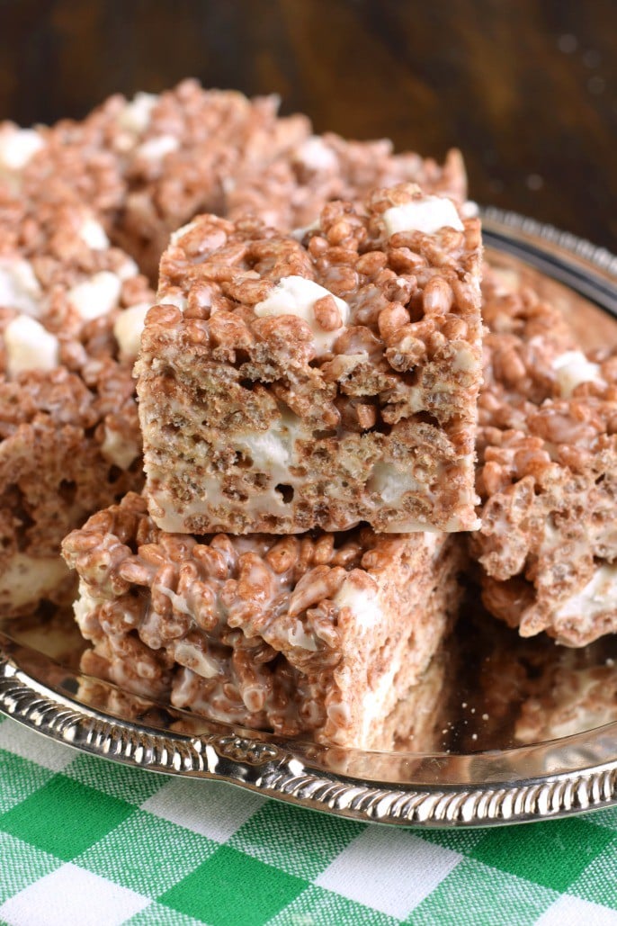 Chocolate rice krispie treats cut into squares on a silver serving tray.