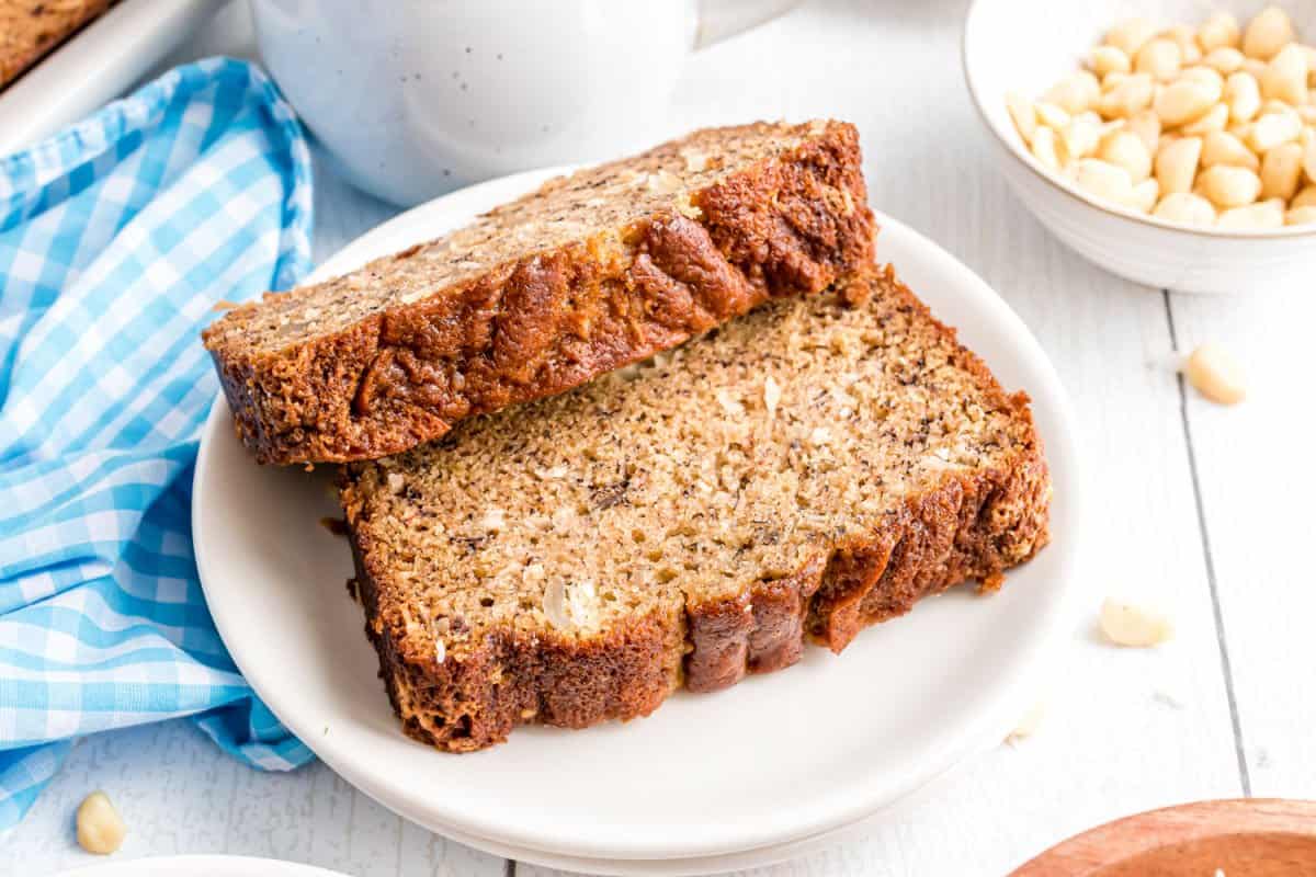 Two slices of banana bread with coconut on a white plate.