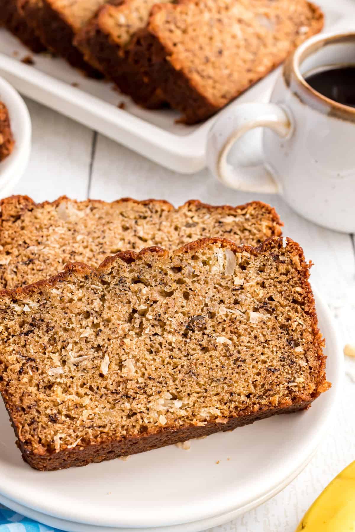 Banana bread with coconut sliced and served on white plates.