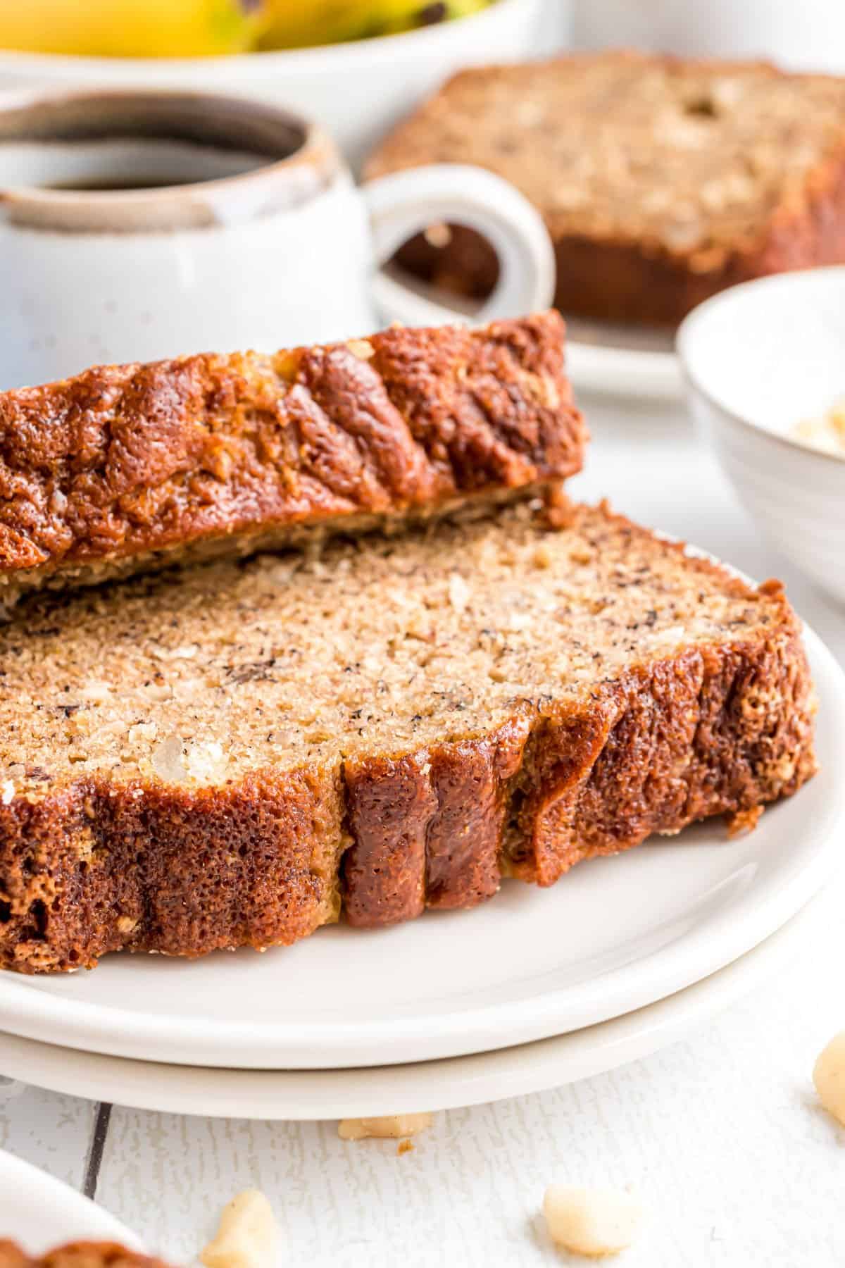 Two slices of coconut banana bread on a white plate.