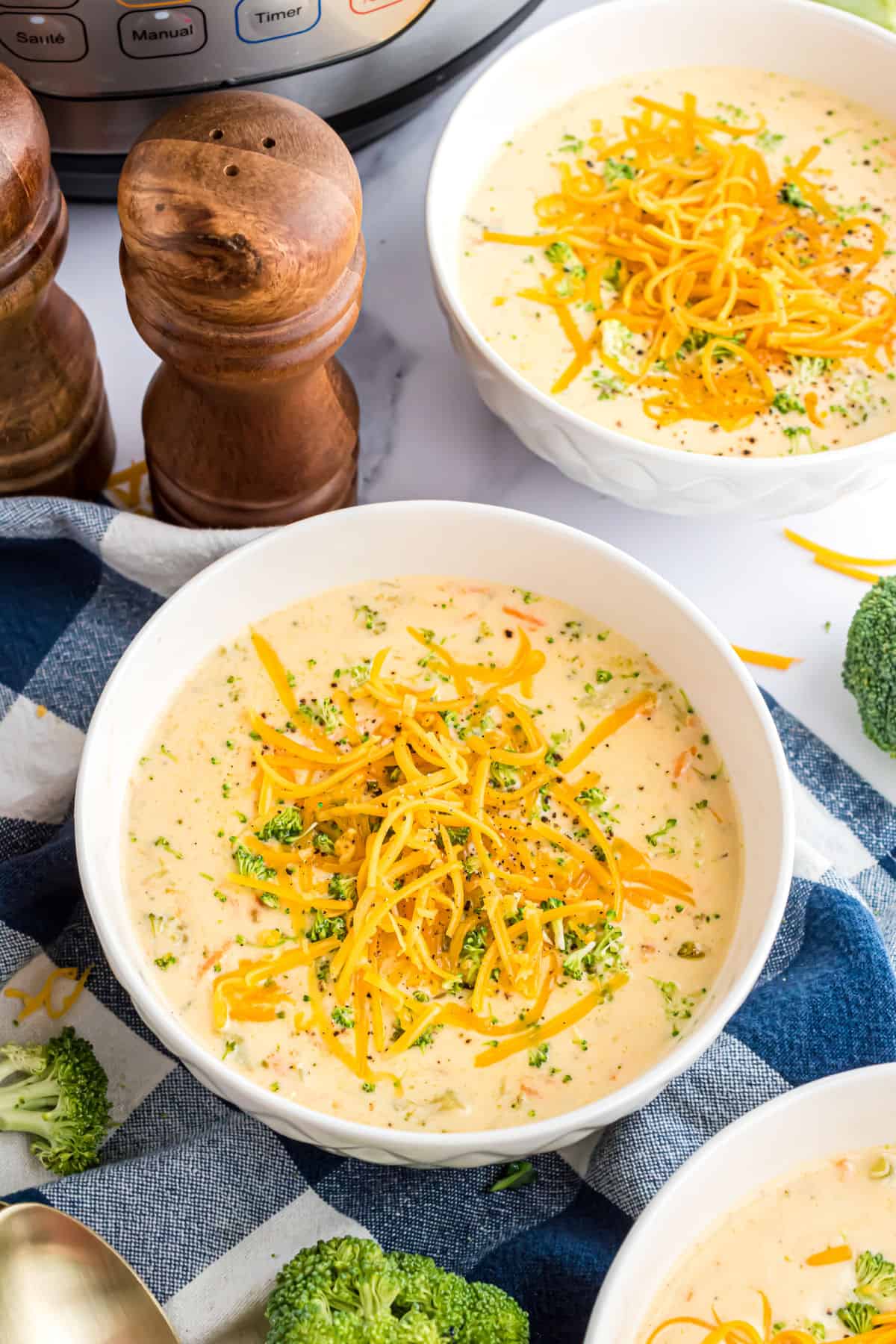 Two bowls of broccoli cheddar soup.