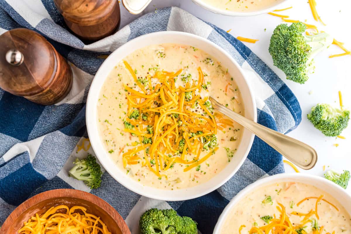 Broccoli cheese soup in a white serving bowl with a spoon.