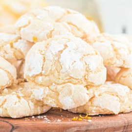 Lemon crinkle cookies on a wooden board.