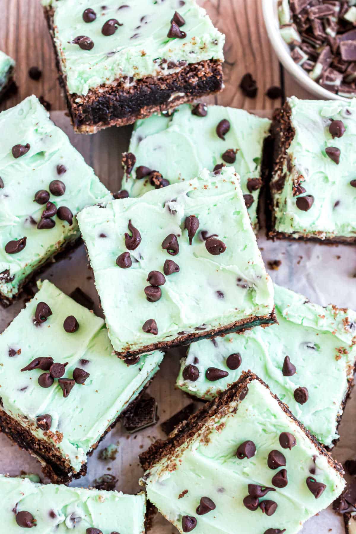 Mint chocolate chip frosted brownie squares stacked up.

