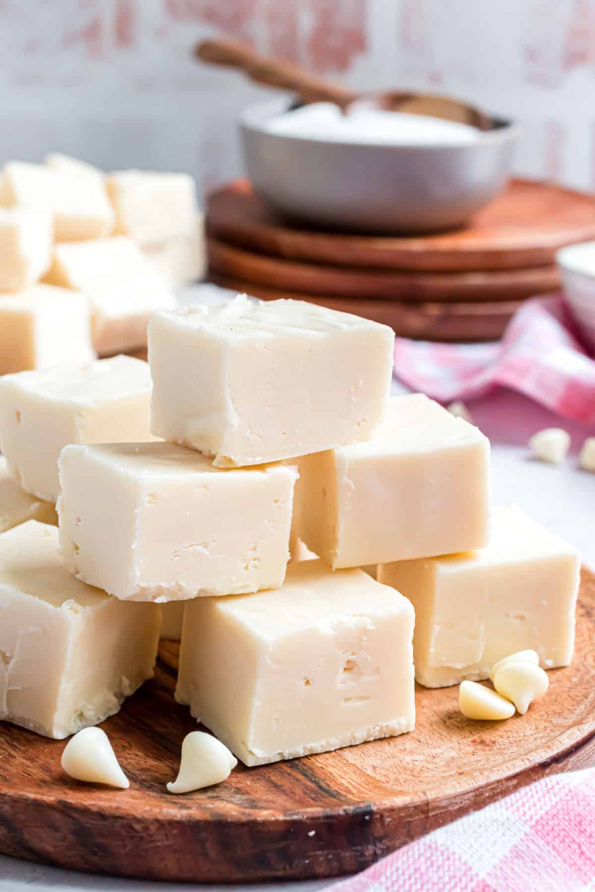 Stacks of vanilla fudge on a wooden serving tray.