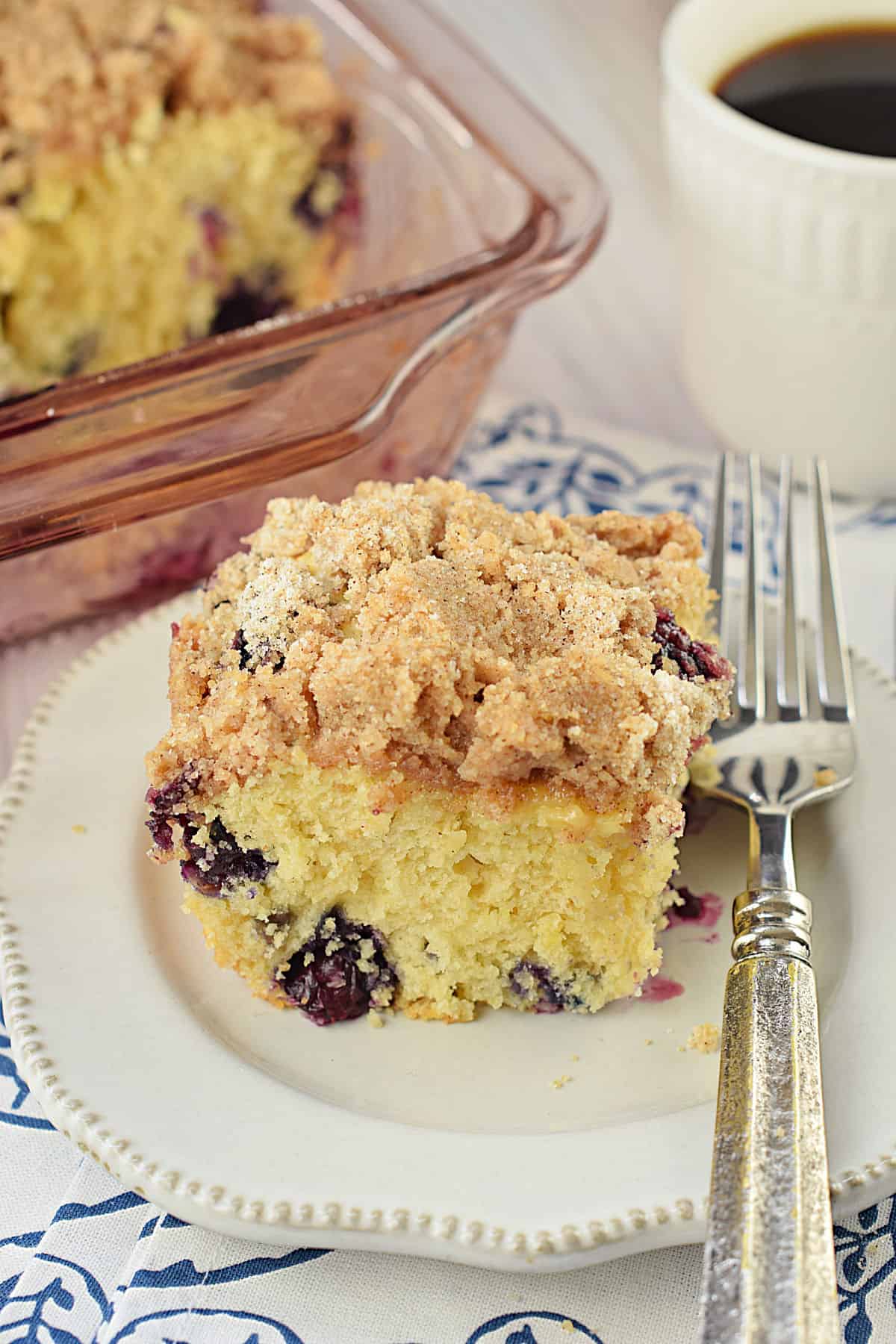 Blueberry cake with streusel on a white plate.