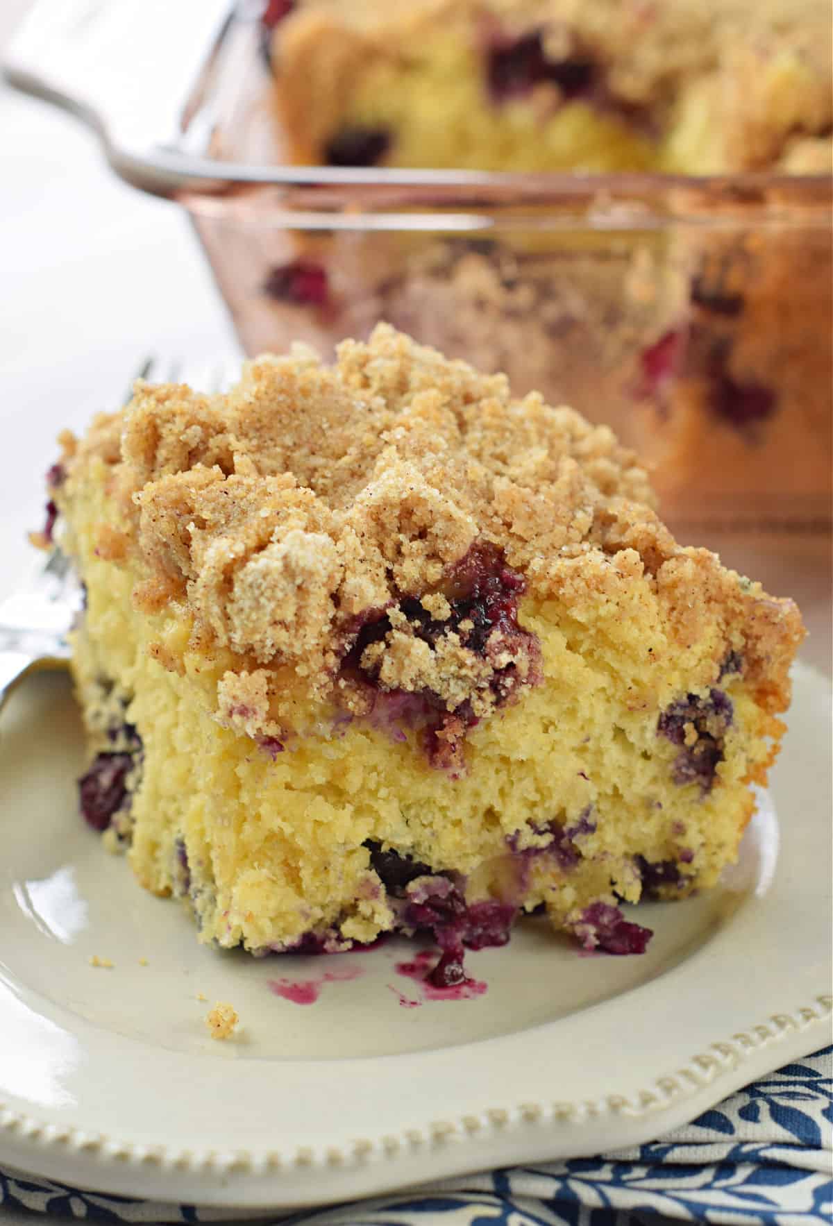 Slice blueberry buckle on a white plate.