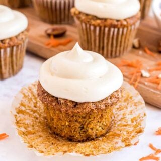 Carrot cake cupcake with paper wrapper undone.