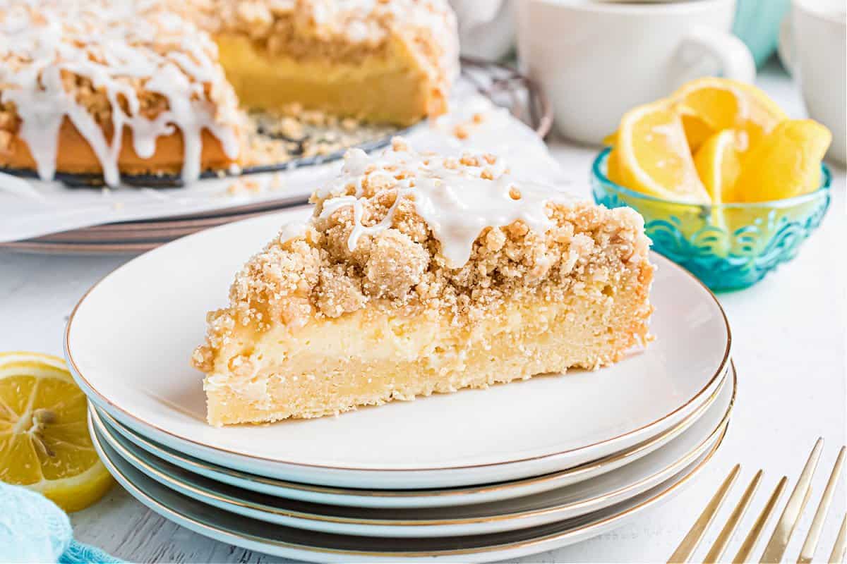 Slice of coffee cake on a stack of white plates.