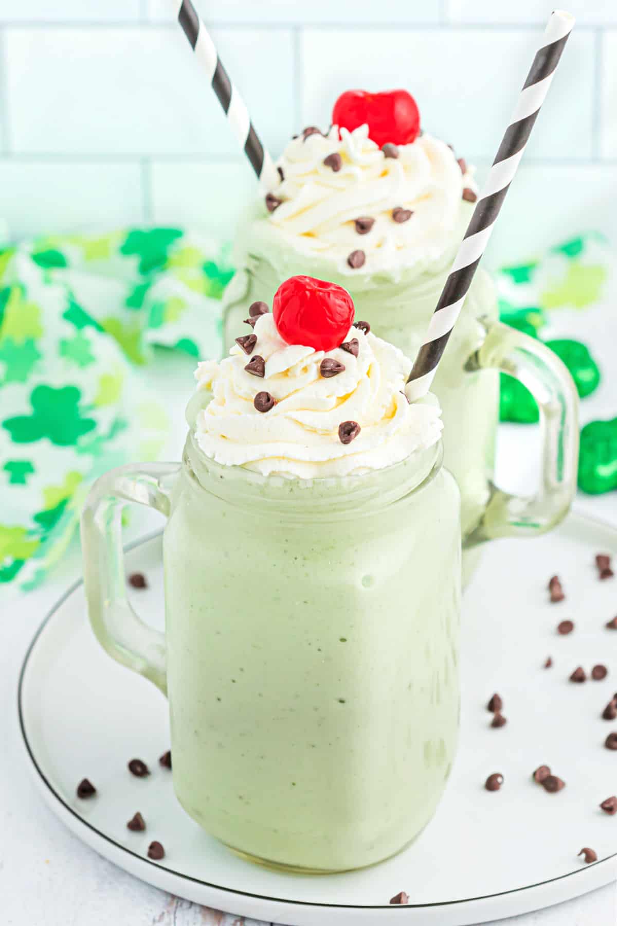Shamrock shake in a glass mugs with whipped cream and a cherry.