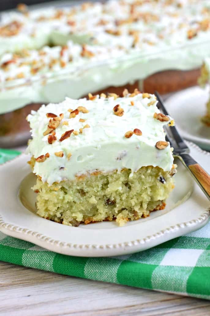 Pistachio cake with pistachio frosting on a plate.