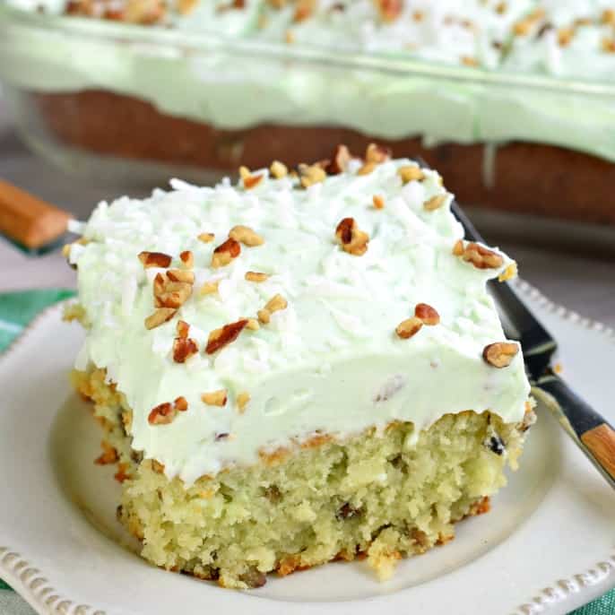 Watergate cake slice topped with pistachio frosting.