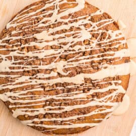 Banana cake on wooden serving board topped with maple glaze.