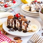 This easy Banana Split Cheesecake recipe is the perfect summer dessert. Layers of graham cracker, cheesecake, pineapple, bananas, strawberries and all the sundae toppings!