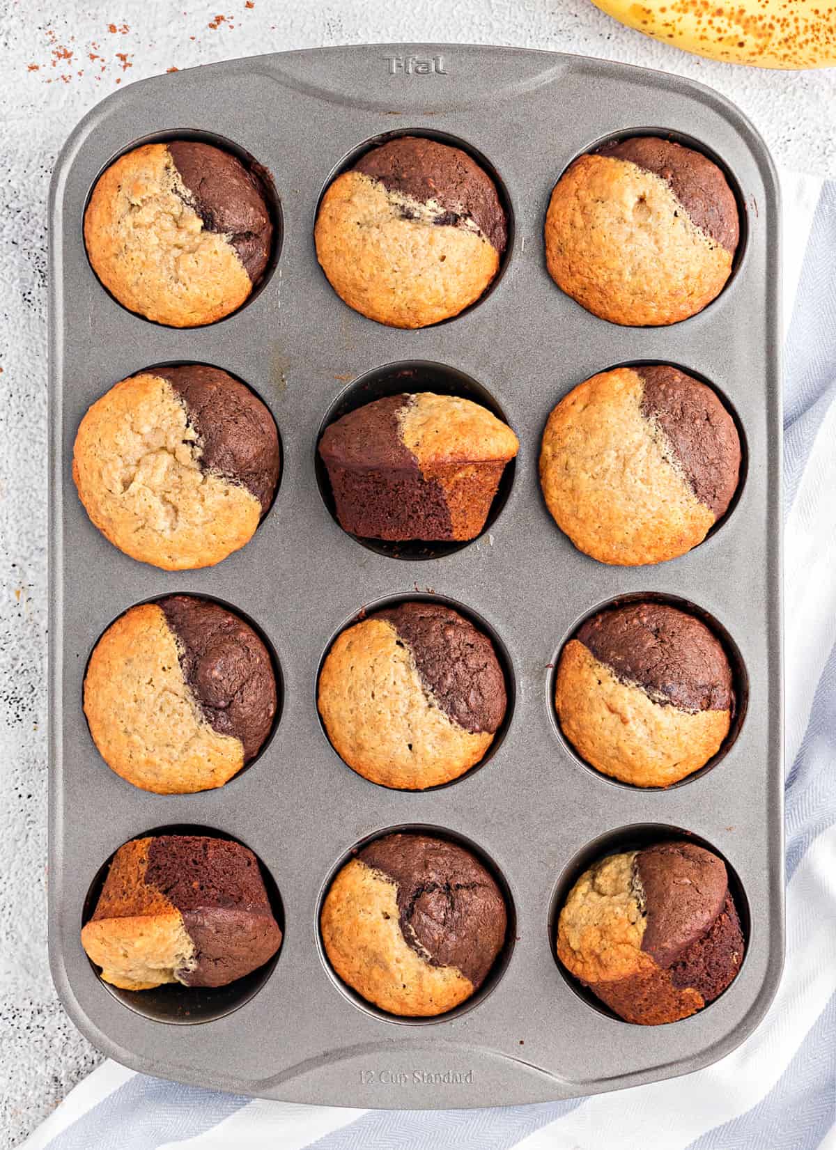 Banana muffins with chocolate in a metal cupcake tin.