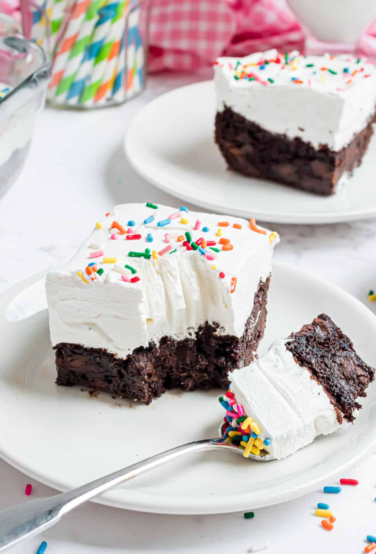 Chocolate cake with cool whip and fork with a bite taken out.