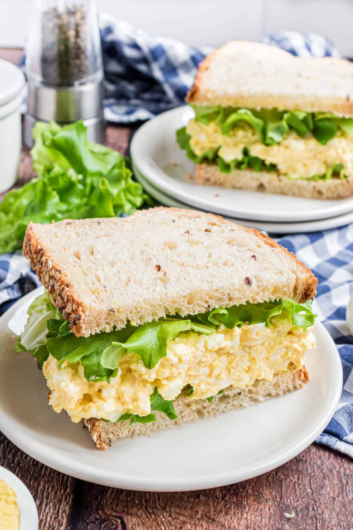 Egg salad on white bread with lettuce.