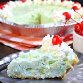 Deliciously easy No Bake Pistachio Pie recipe is filled with cream cheese, pineapple, and marshmallows in a graham cracker crust! You'll love this sweet treat at your next potluck or holiday party.