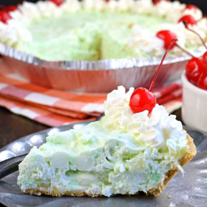 Deliciously easy No Bake Pistachio Pie recipe is filled with cream cheese, pineapple, and marshmallows in a graham cracker crust! You'll love this sweet treat at your next potluck or holiday party.