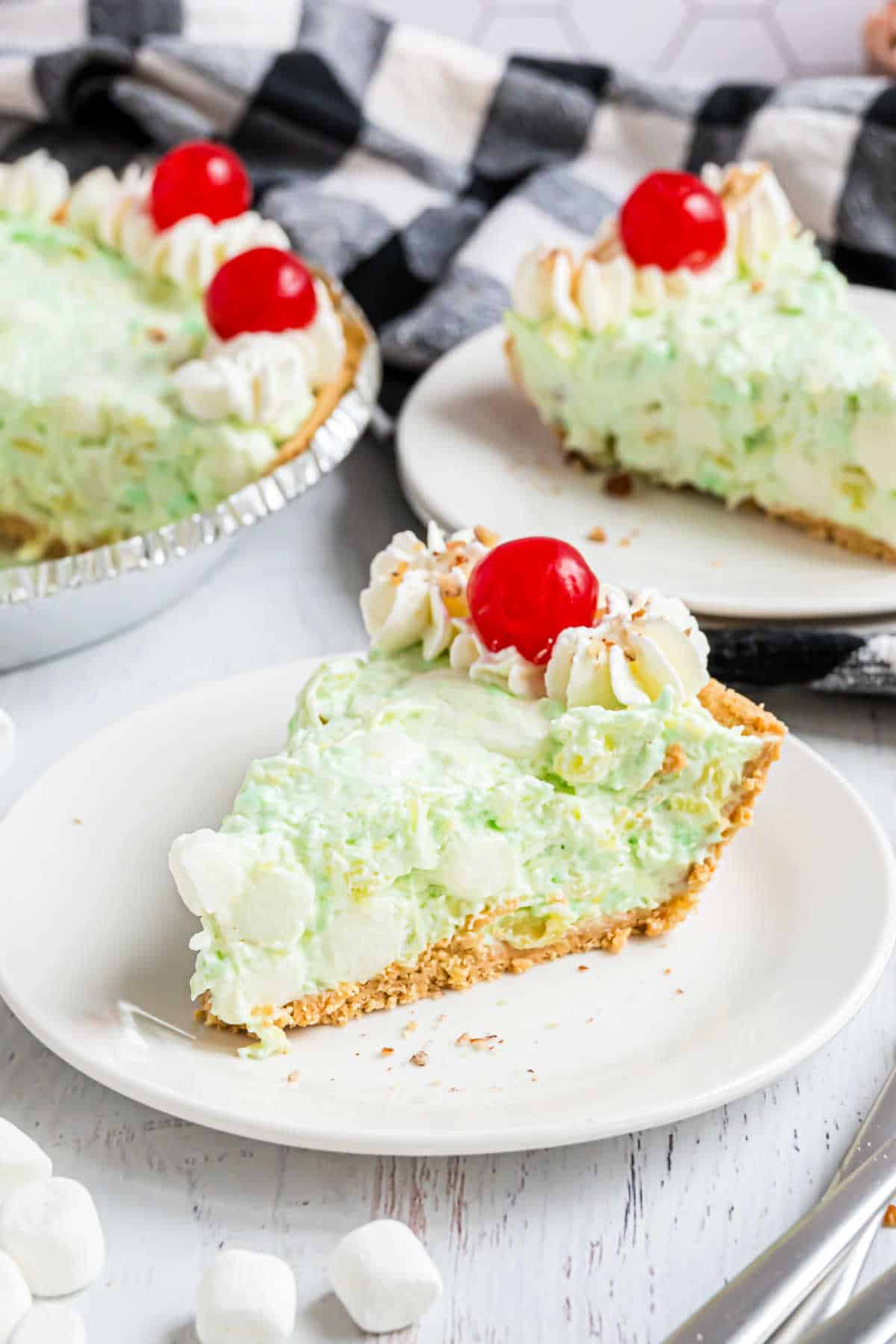 Slice of pistachio pudding pie served on a white plate.