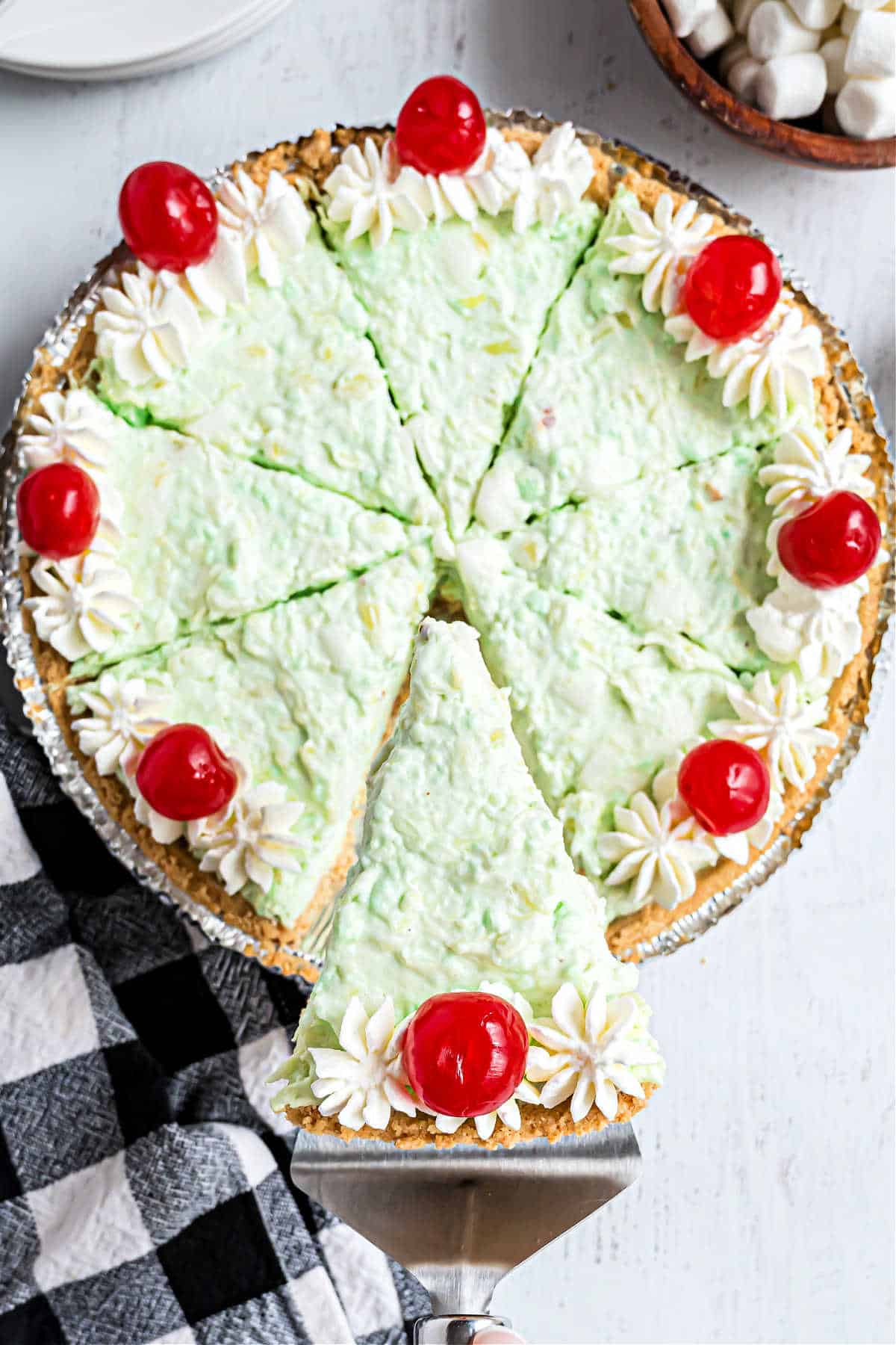 Pistachio pudding pie with a slice being removed.