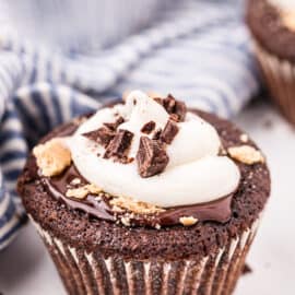 Chocolate cupcake topped with ganache, marshmallow frosting and graham cracker crumbs.