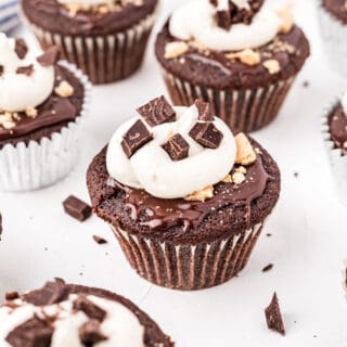 Bring the campfire experience indoors with these S'mores Cupcakes! Rich, fudgy chocolate cupcakes are topped with chocolate ganache, marshmallow frosting and graham cracker crumbs. Experience the summer time s'mores magic all year long!