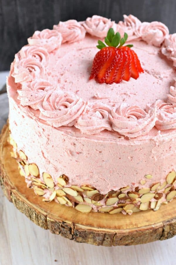 This gorgeous, from scratch, Strawberry Almond Cake recipe features a moist almond layer cake with strawberry buttercream. Fresh sliced almonds and strawberries to added flavor and texture!