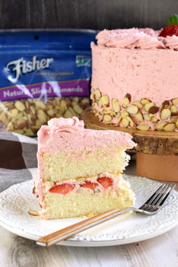 This gorgeous, from scratch, Strawberry Almond Cake recipe features a moist almond layer cake with strawberry buttercream. Fresh sliced almonds and strawberries to added flavor and texture!