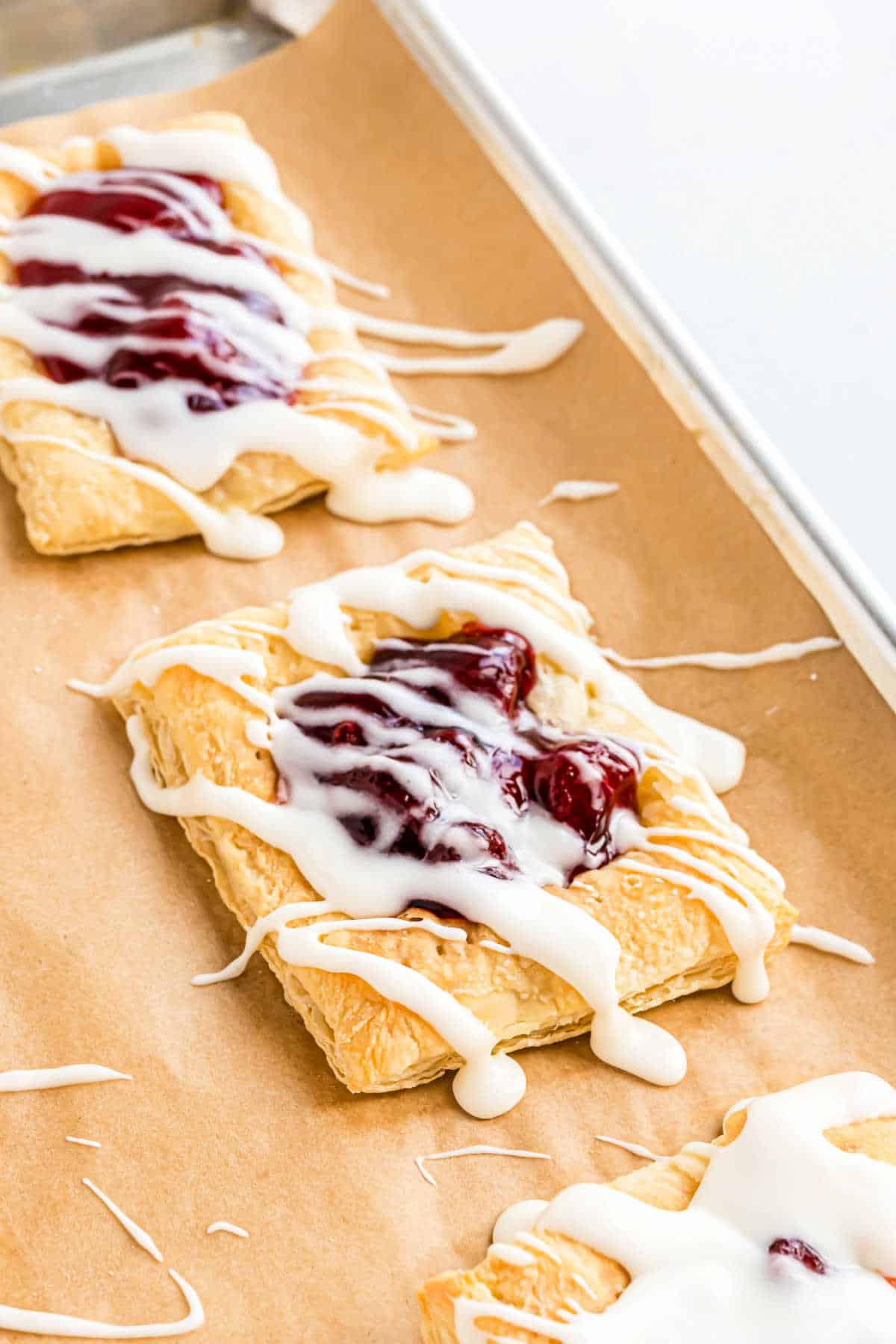 Puff pastry with pie filling on parchment paper lined cookie sheet.