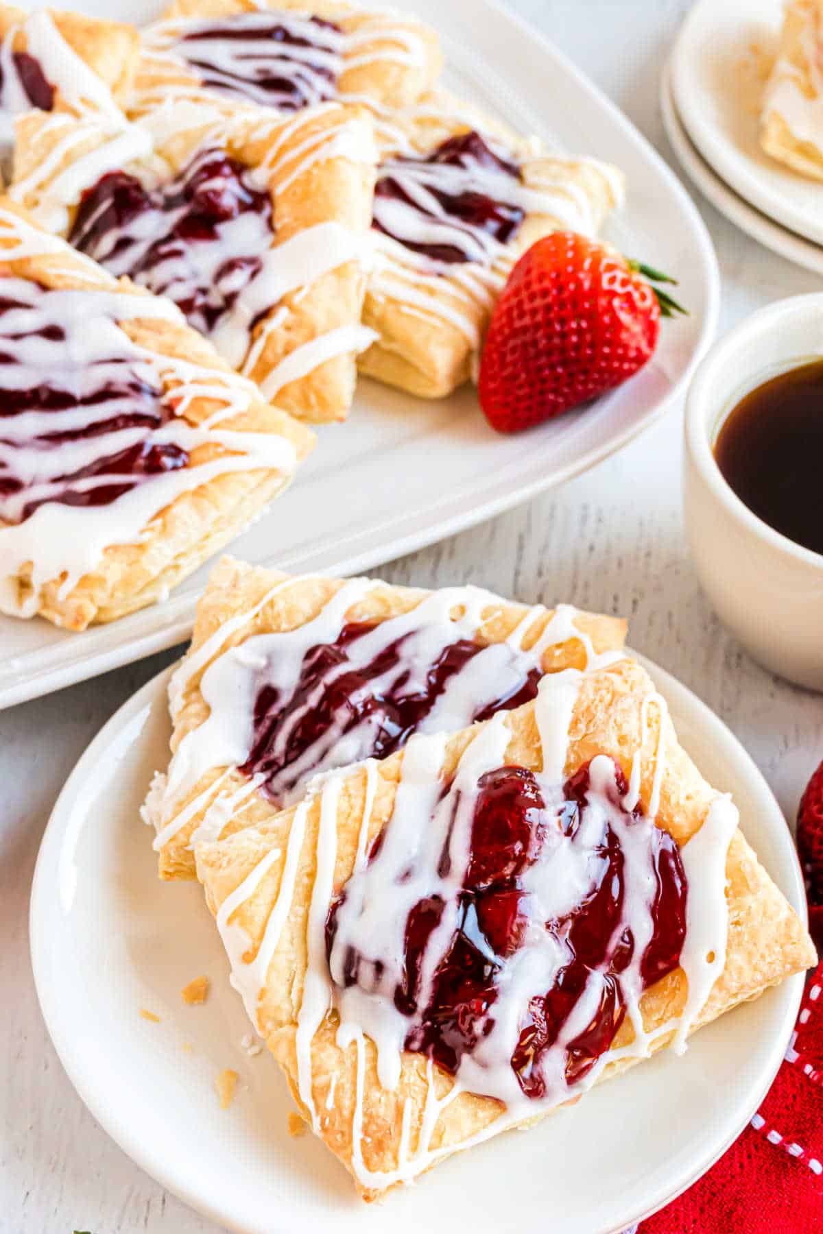 Two homemade strawberry toaster strudels on a white plate.