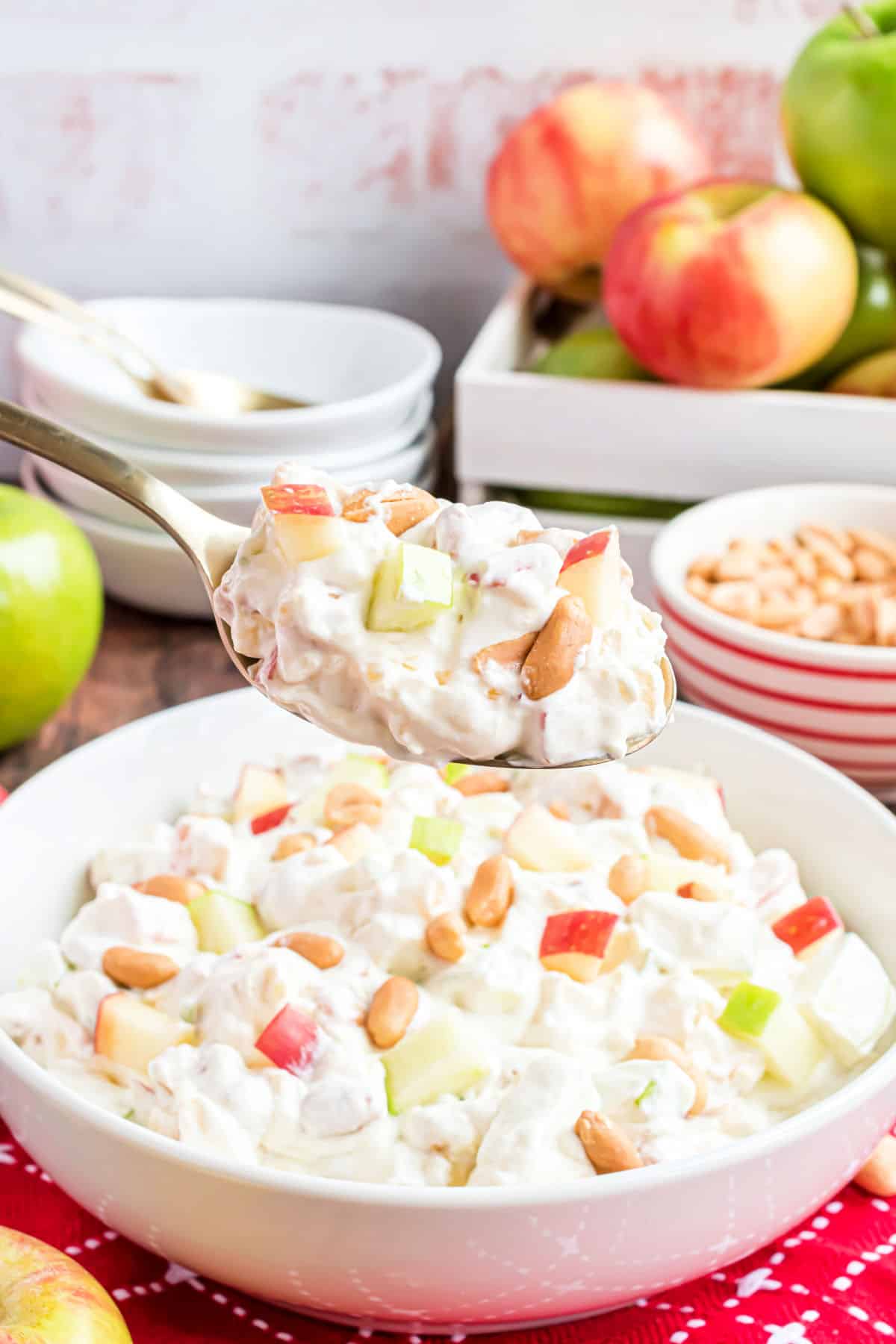 Taffy apple salad in a bowl with a serving spoon.