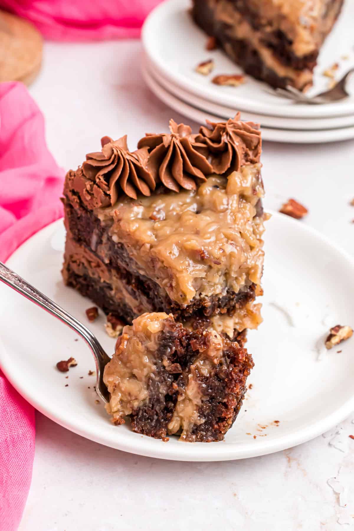 Slice of german chocolate cake with a bite taken out.