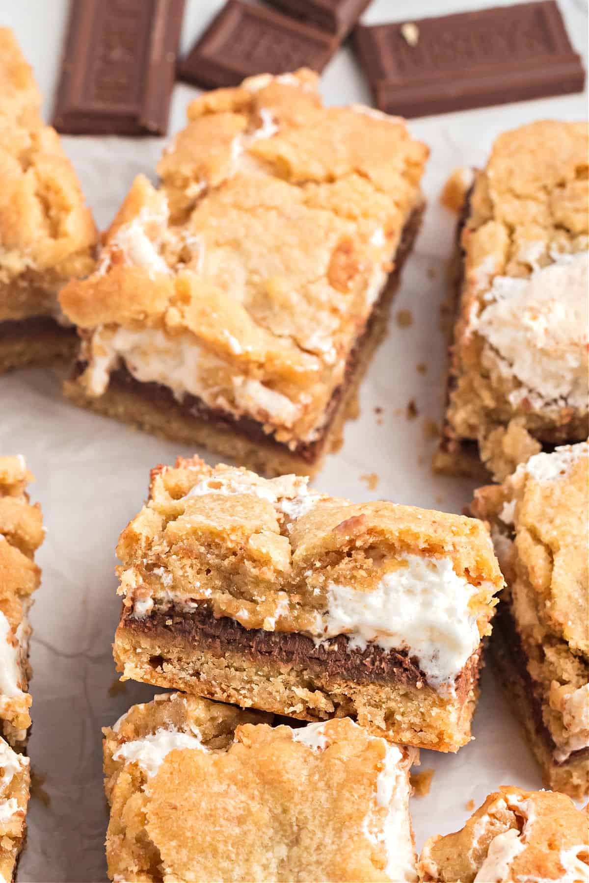Smores cookie bars cut into squares on parchment paper.
