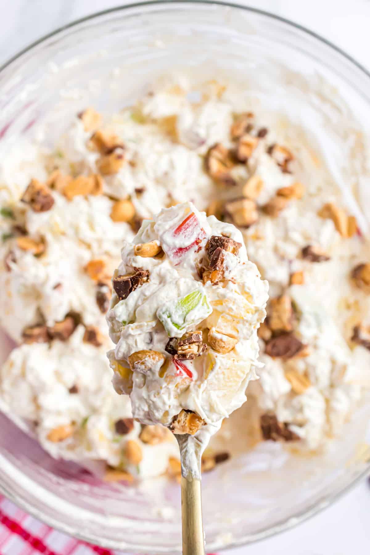 Snicker salad being spooned out of a bowl.