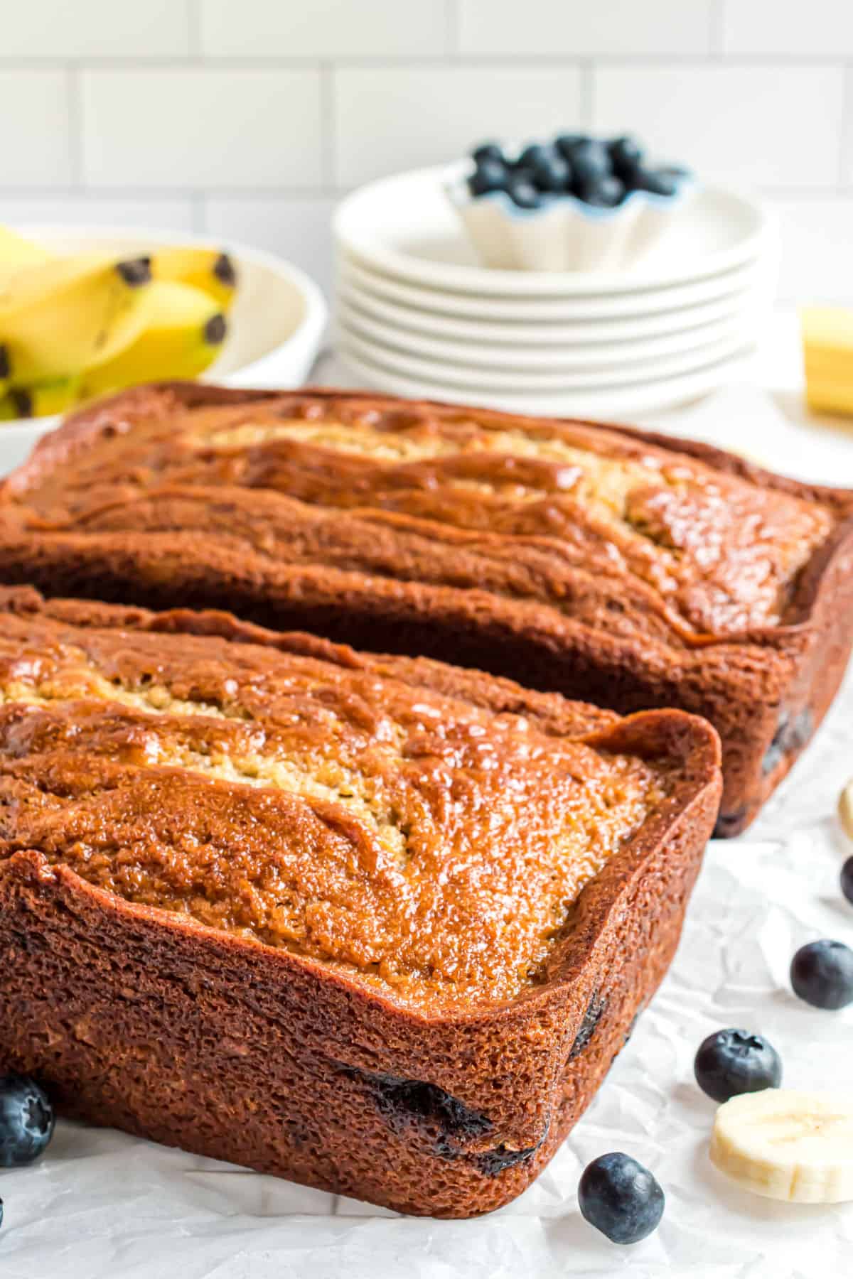 Two loaves of blueberry banana bread on counter.