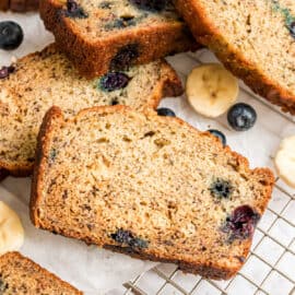 Blueberry banana bread slices on a wire rack.