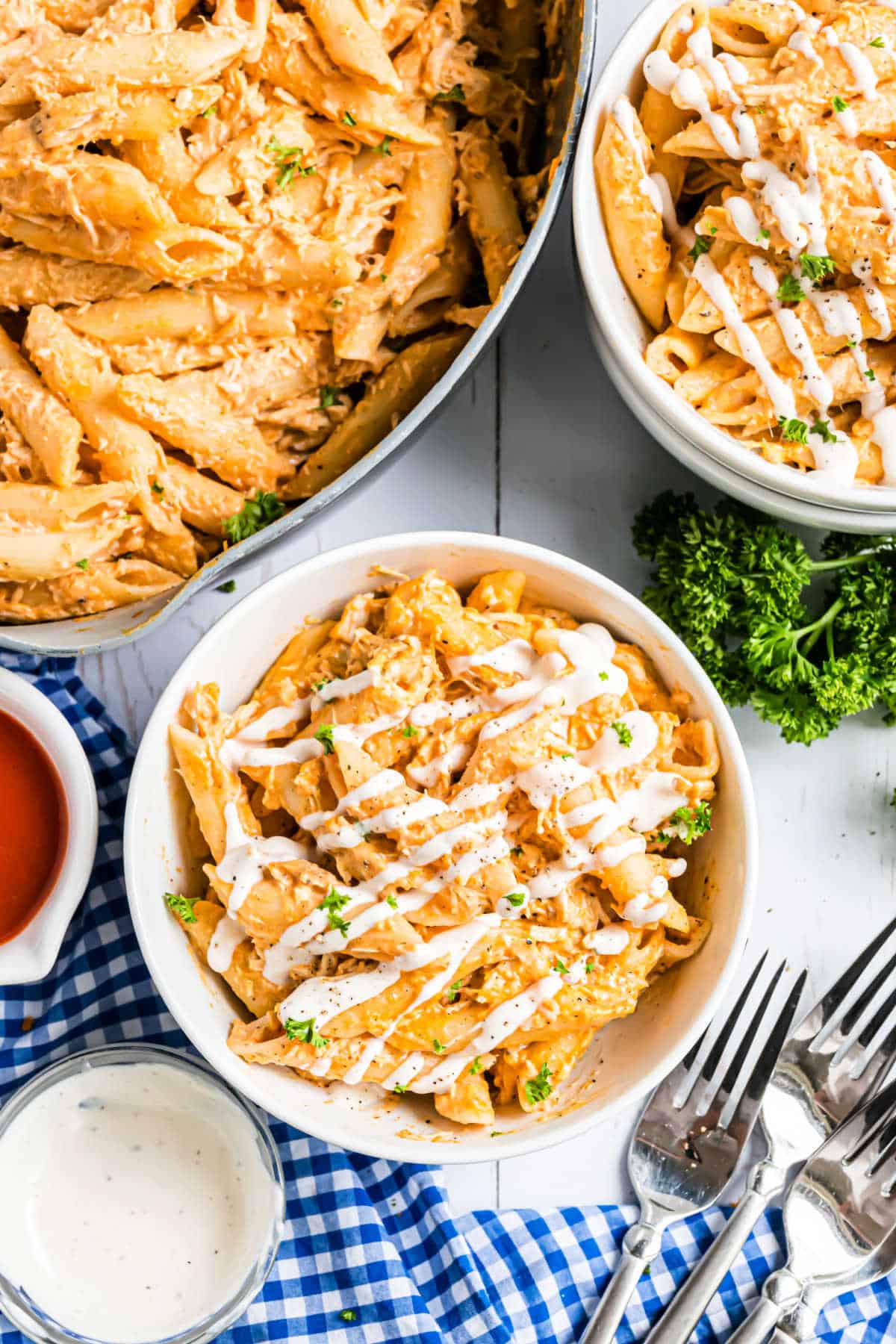 Buffalo chicken pasta served in a bowl drizzled with blue cheese dressing.