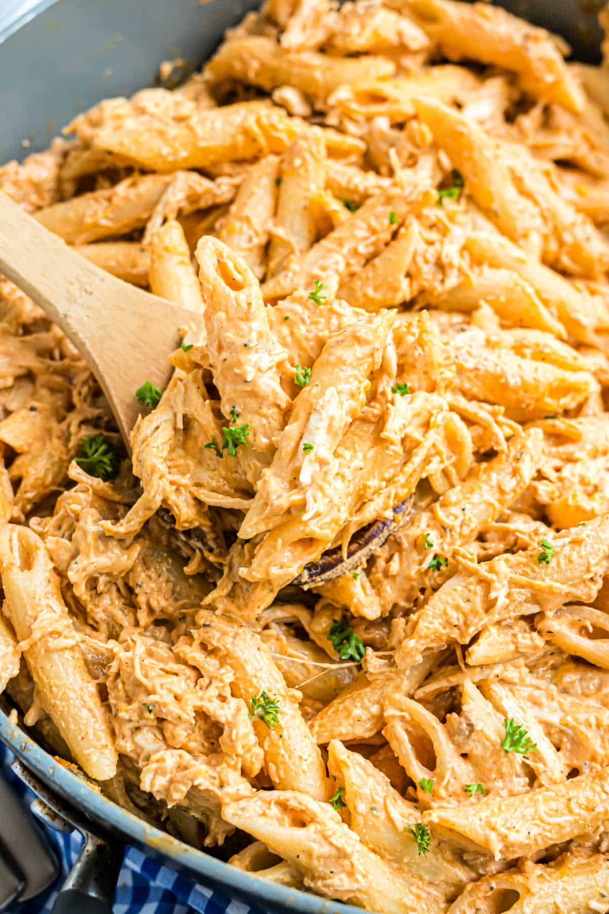 Pasta with chicken and buffalo sauce in a skillet.