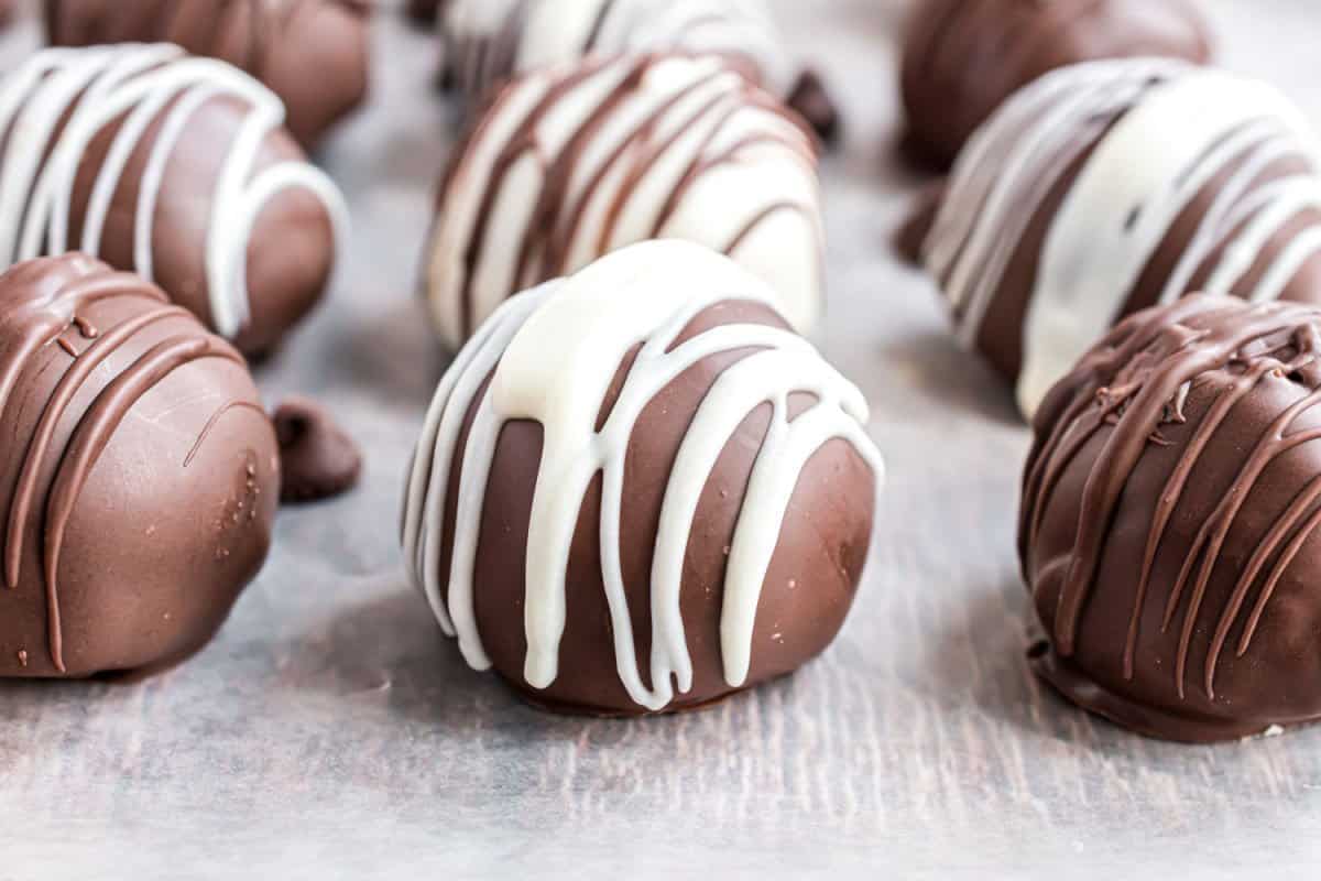 Cookie dough truffles dipped in chocolate and drizzled with white chocolate.