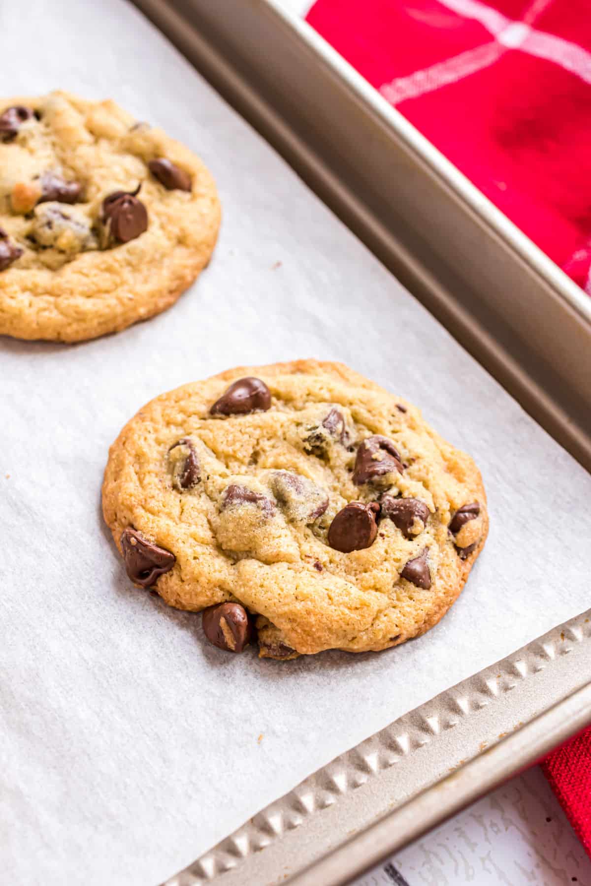 Chocolate chip pudding cookies on parchment paper lined cookie sheet.