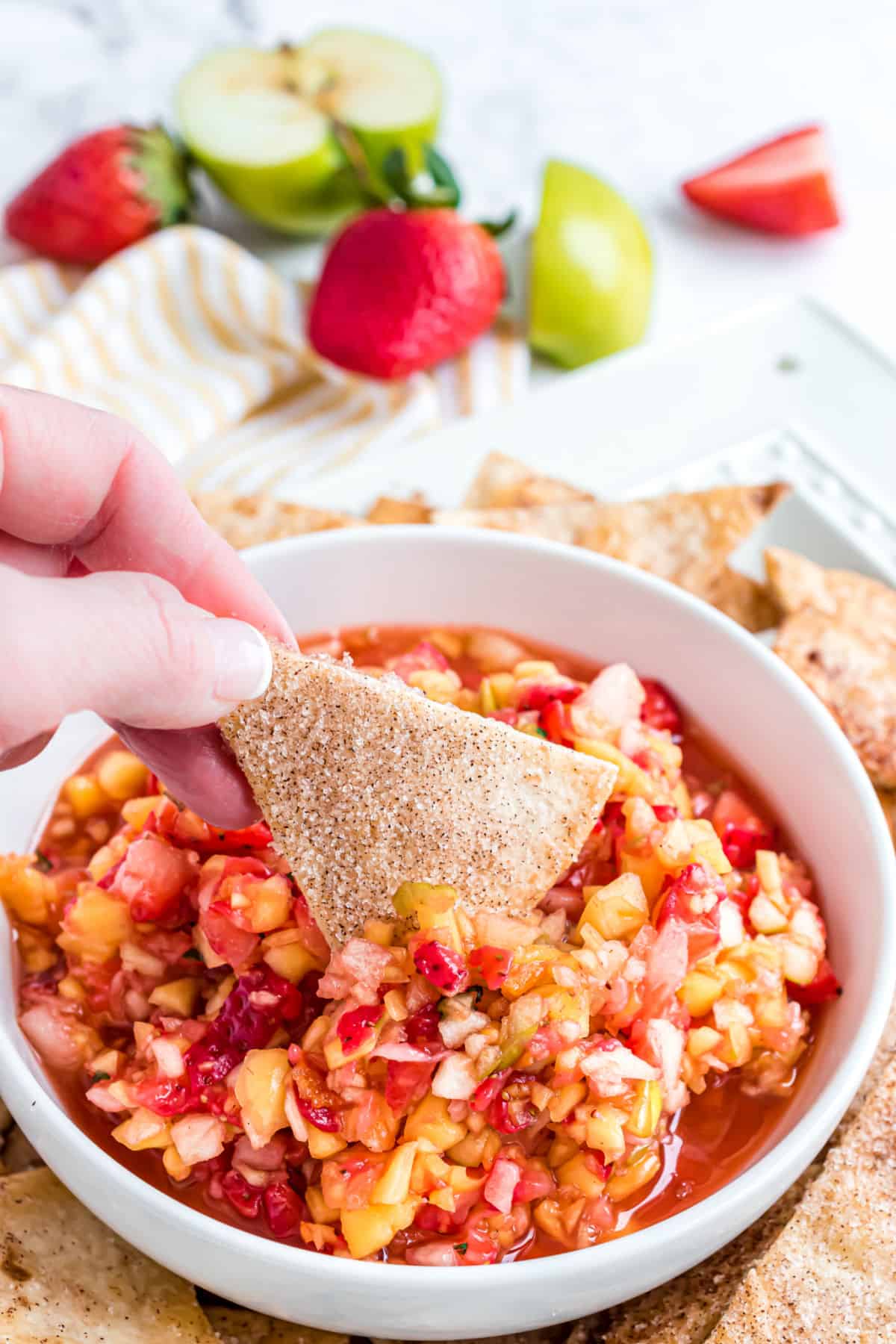 Fruit salsa in a white bowl with homemade cinnamon tortilla chips.