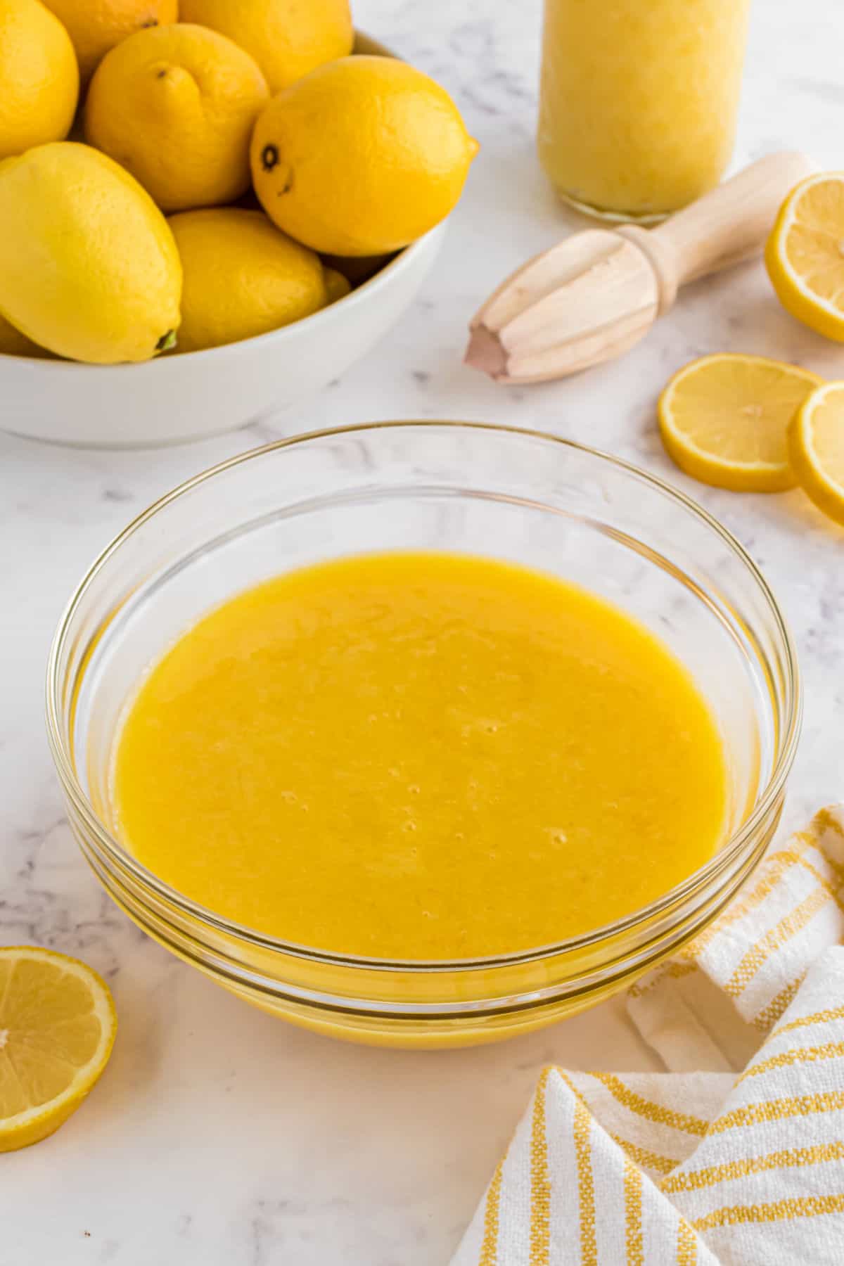 Lemon curd in a clear glass bowl.