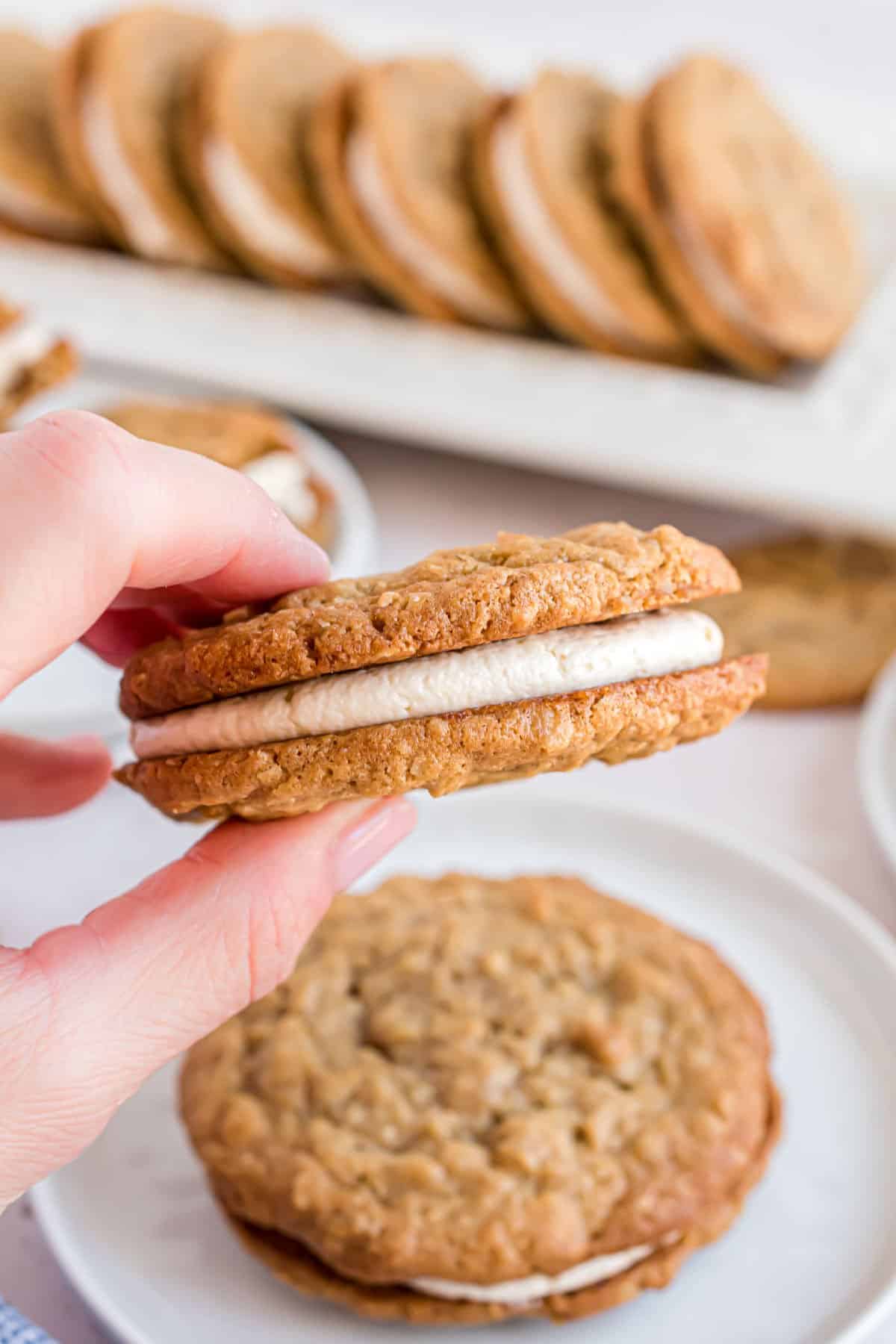 Oatmeal Cream pies being held up to take a bite.